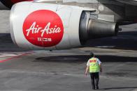 A ground crew member of AirAsia, a subsidiary airline of Capital A, walks on the tarmac of Kuala Lumpur International Airport Terminal 2 (KLIA2) in Sepang