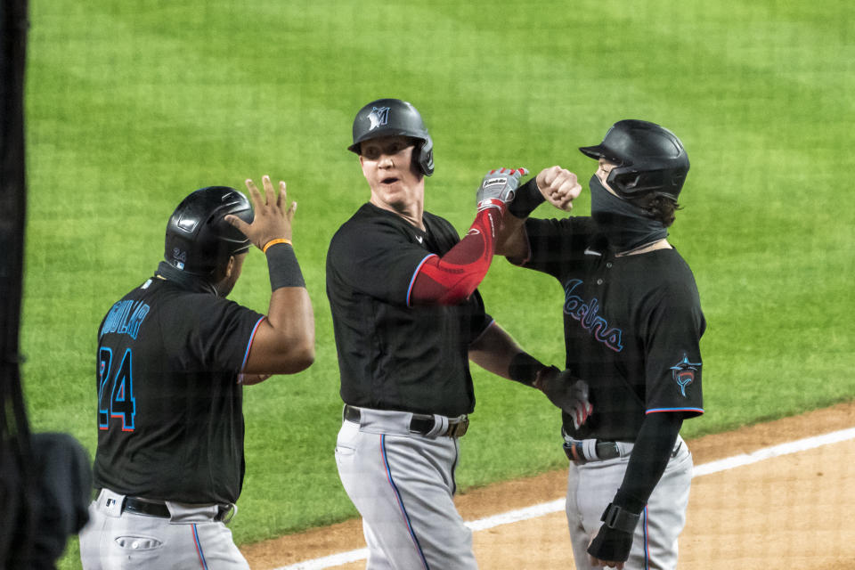 Miami Marlins' Garrett Cooper at center celebrates his three-run home run with Jesus Aguilar at left and Brian Anderson during the first inning of a baseball game against the New York Yankees at Yankee Stadium, Friday, Sept. 25, 2020, in New York. (AP Photo/Corey Sipkin)