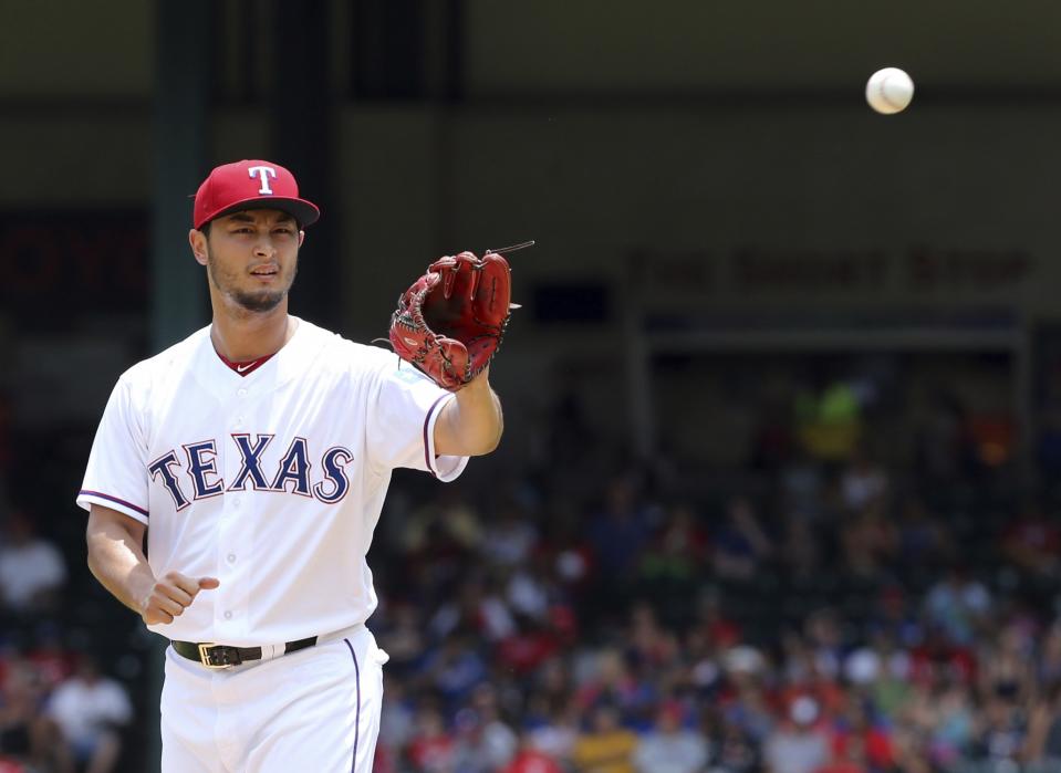 Texas Rangers starting pitcher Yu Darvish gets the ball returned to him as he works the first inning of a baseball game against the Los Angeles Angels in Arlington, Texas, Sunday, July 9, 2017