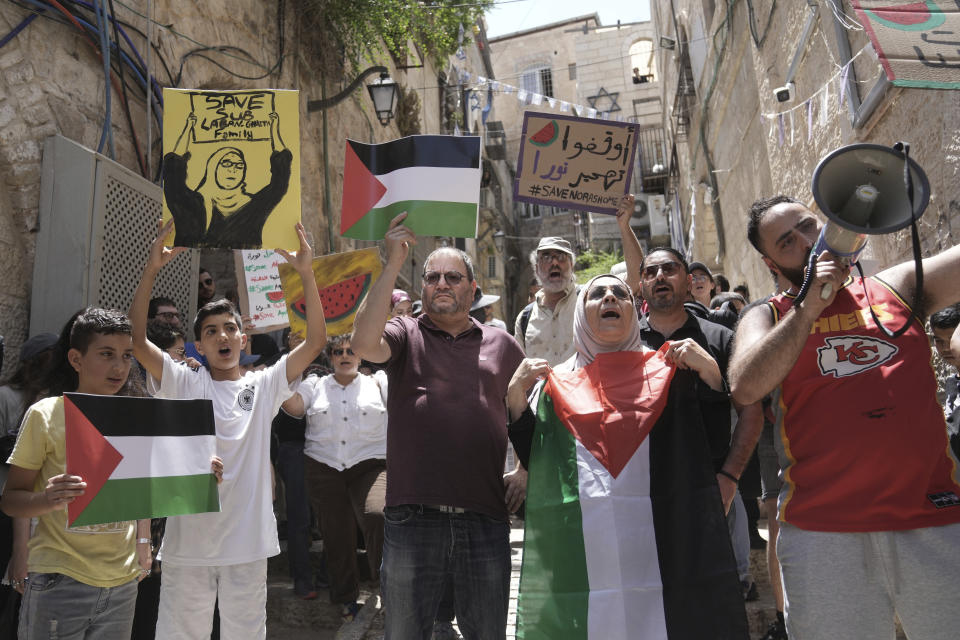 FILE - Israeli lawmaker Ofer Cassif, center, holds a representation of a Palestinian flag during a protest against the imminent eviction of Nora, second right, and Mustafa Ghaith-Sub Laban and their family by a Jewish settler organization, outside of their home in the Old City of Jerusalem, Friday, June 16, 2023. The family has battled Israeli attempts to force them out for the past 45 years. The campaign ended this spring, when the Israeli Supreme Court struck down their final appeal in favor of Jewish settlers contending they violated the lease. Now, Israeli authorities have ordered the eviction of the family to take place by July 13. (AP Photo/Mahmoud Illean, File)