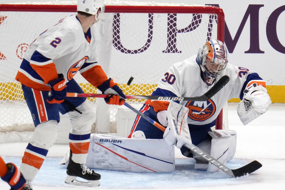 A shot by Pittsburgh Penguins' Marcus Pettersson gets past New York Islanders goaltender Ilya Sorokin (30) for a goal with Mike Reilly (2) defending during the first period of an NHL hockey game in Pittsburgh, Tuesday, Feb. 20, 2024. (AP Photo/Gene J. Puskar)