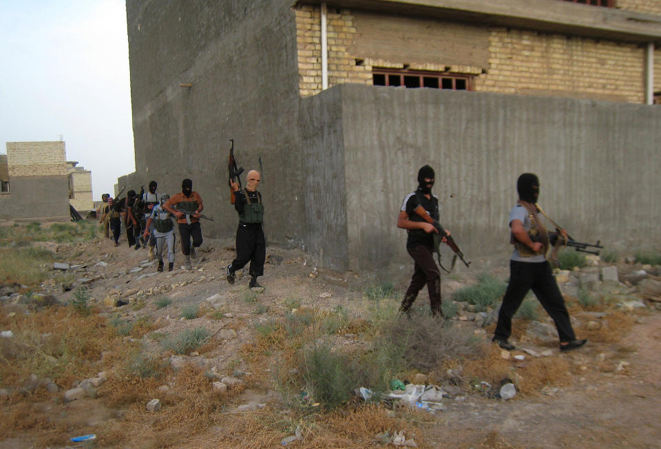 FILE -- In this Monday, April 28, 2014 file photo, masked anti-government gunmen move with their weapons as they patrol in Fallujah, Iraq. Militants, many from the al-Qaida-breakaway group Islamic State in Iraq and the Levant, overran Fallujah and parts of Anbar’s capital, Ramadi, at the beginning of the year, taking advantage of tensions between the Sunni community, which dominates Anbar, and the Shiite-led central government. Fighting has dislodged thousands of residents from their homes and forced shutdowns of their businesses. (AP Photo, File)