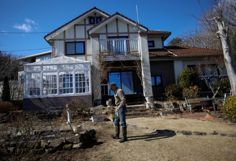 The Wider Image: Japan's tsunami survivors call lost loves on the phone of the wind