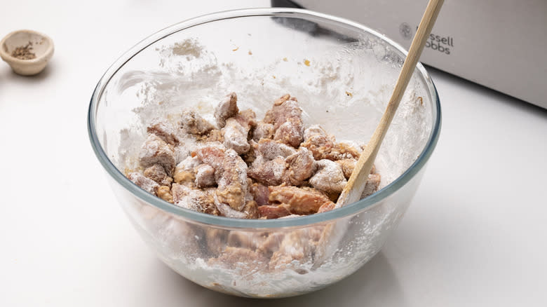 marinated pork coated in cornstarch in bowl