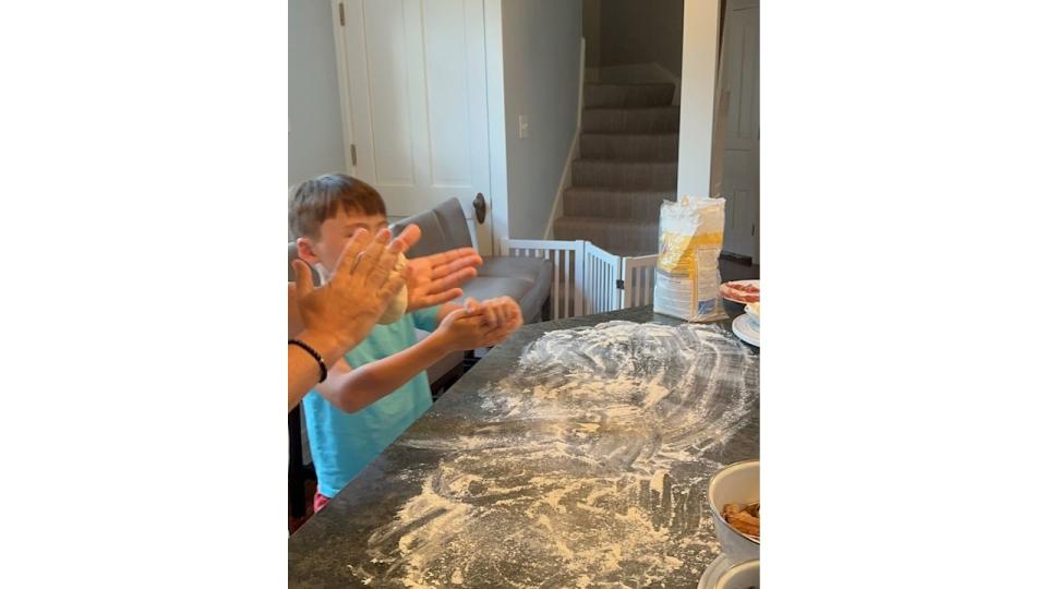 Wolfie making pizza at a kitchen table