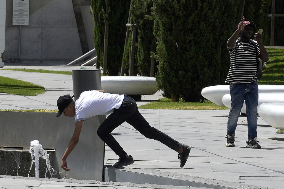 A man touches water from a fountain amid hot weather at Eleftherias, Liberty, square in central capital Nicosia, Cyprus, on Friday, June 14, 2024. (AP Photo/Petros Karadjias)