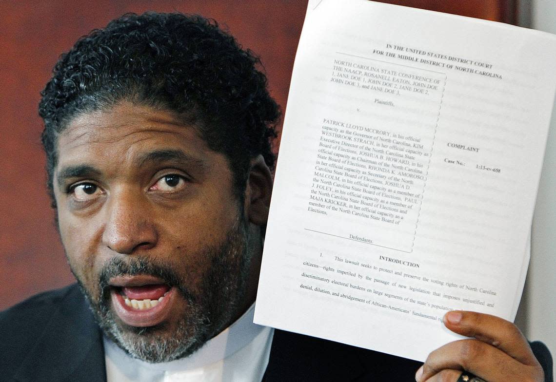 The Rev. William Barber, then-president of the N.C. NAACP, holds up a copy of a lawsuit on August 13, 2013 as he announces that the group is filing a lawsuit against the recently passed Voter ID.