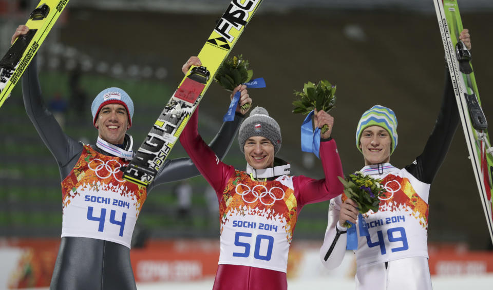 Poland's gold medal winner Kamil Stoch is flanked by Norway's bronze medal winner Anders Bardal, left, and Slovenia's silver medal winner Peter Prevc after the the men's normal hill ski jumping final at the 2014 Winter Olympics, Sunday, Feb. 9, 2014, in Krasnaya Polyana, Russia. (AP Photo/Matthias Schrader)