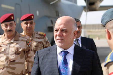 Iraqi Prime Minister Haider al-Abadi walks with officers as he arrives in Mosul, Iraq, March 14, 2018. Iraqi Prime Minister Media Office/Handout via REUTERS