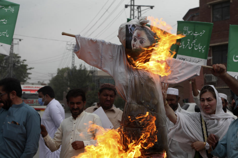 Pakistani people burn an effigy depicting former Bharatiya Janata Party spokeswoman Nupur Sharma during a demonstration to condemn derogatory references to Islam and the Prophet Muhammad recently made by Sharma, a spokesperson of the governing Indian Hindu nationalist party, Friday, June 10, 2022, in Peshawar, Pakistan. (AP Photo/Mohammad Sajjad)