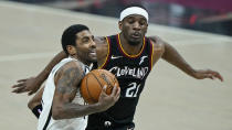 Brooklyn Nets' Kyrie Irving, front, drives to the basket against Cleveland Cavaliers' Damyean Dotson during the second half of an NBA basketball game, Wednesday, Jan. 20, 2021, in Cleveland. The Cavaliers won 147-135 in double-overtime. (AP Photo/Tony Dejak)
