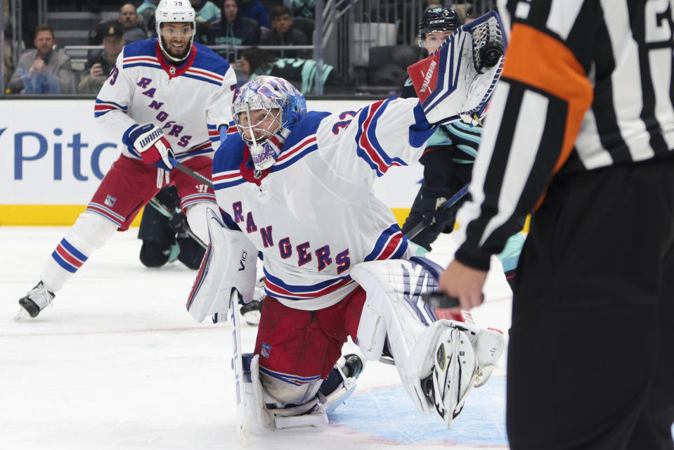 New York Rangers goaltender Jonathan Quick (32) makes a glove save during the second period of an NHL hockey game against the Seattle Kraken, Saturday, Oct. 21, 2023, in Seattle. (AP Photo/Jason Redmond)