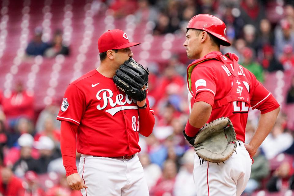 Cincinnati Reds starting pitcher Luis Cessa, left, talks with catcher Luke Maile, right, after walking a batter during the first inning of a baseball game against the Philadelphia Phillies, Sunday, April 16, 2023, in Cincinnati.