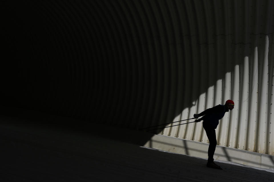 A cross country skier goes through a tunnel during a training session prior to the 2014 Winter Olympics, Friday, Feb. 7, 2014, in Krasnaya Polyana, Russia. (AP Photo/Felipe Dana)