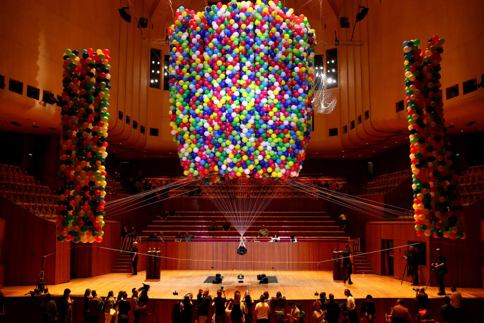 Austrian British artist No&euml;mi Lakmaier is seen suspended by 20,000 helium-filled balloons inside of the Sydney Opera House on Sunday. (Photo: Cameron Spencer via Getty Images)