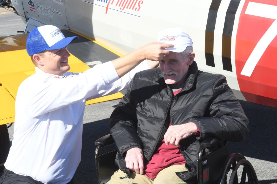 Dream Flights pilot James Sims (left) puts a signed Dream Flights cap on Ira Campbell after they flew in a World War II bi-plane at Esler Field. Central Management Company partnered with Dream Flights to offer rides on the plane to veterans at local nursing homes. Campbell was a contractor who drove trucks in Vietnam in 1972-73.