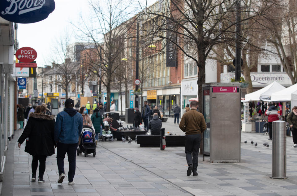 People make their way along the High street in Slough, Berkshire, in the final week of a four week national lockdown to curb the spread of coronavirus.