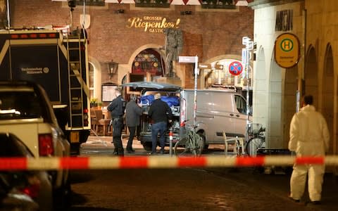 A body is loaded into a vehicle in front of the restaurant in Muenster, Germany - Credit: David Young/dpa via AP