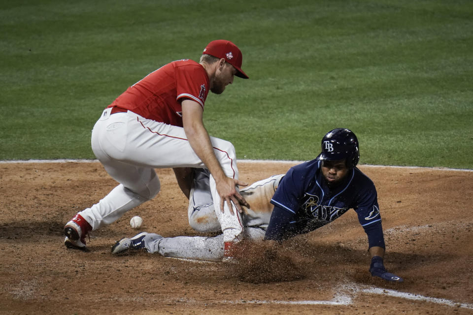 Tampa Bay Rays' Manuel Margot, right, scores as Los Angeles Angels relief pitcher Aaron Slegers misses the throw during the eighth inning of a baseball game Thursday, May 6, 2021, in Anaheim, Calif. (AP Photo/Jae C. Hong)