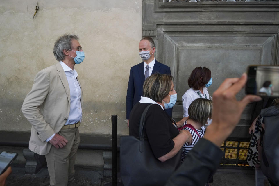 Uffizi museum director Eike Schmidt, center, looks at the first visitors arriving on the reopening day of the museum, in Florence, Wednesday, June 3, 2020. The Uffizi museum reopened to the public after over two months of closure due to coronavirus restrictions. (AP Photo/Andrew Medichini)