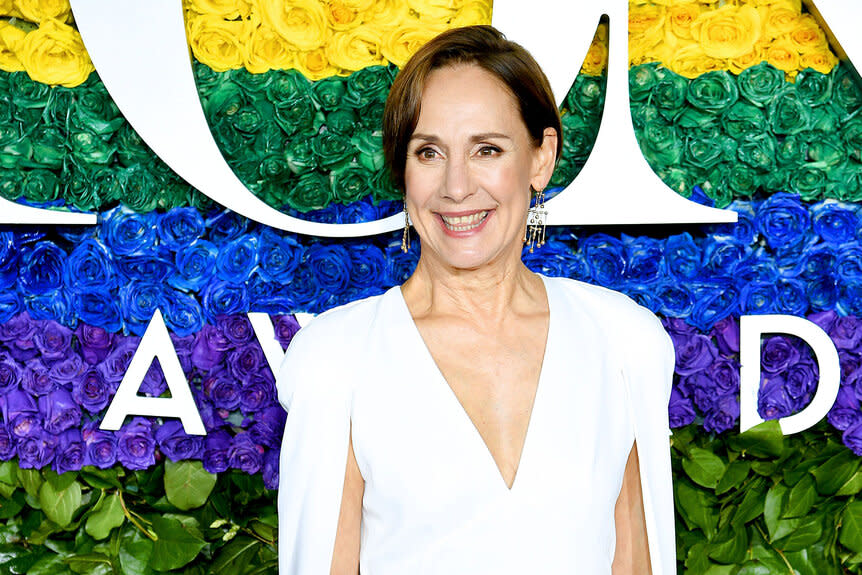 Laurie Metcalf smiles and poses on the red carpet of the Tony Awards