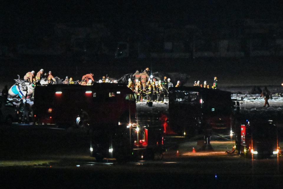 Rescue crews work at the site where a Japan coast guard aircraft collided with a Japan Airlines (JAL) passenger plane on the tarmac at Tokyo International Airport (AFP via Getty Images)