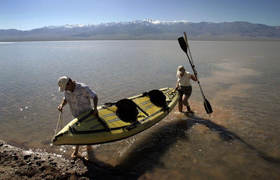 Jay Shapiro, left, of Thousand Oaks, California, and Cheryl Cox, of Ventura, California come ashore after kayaking in a giant lake in the bottom of Death Valley caused by heavy flooding in 2005 (Getty Images)