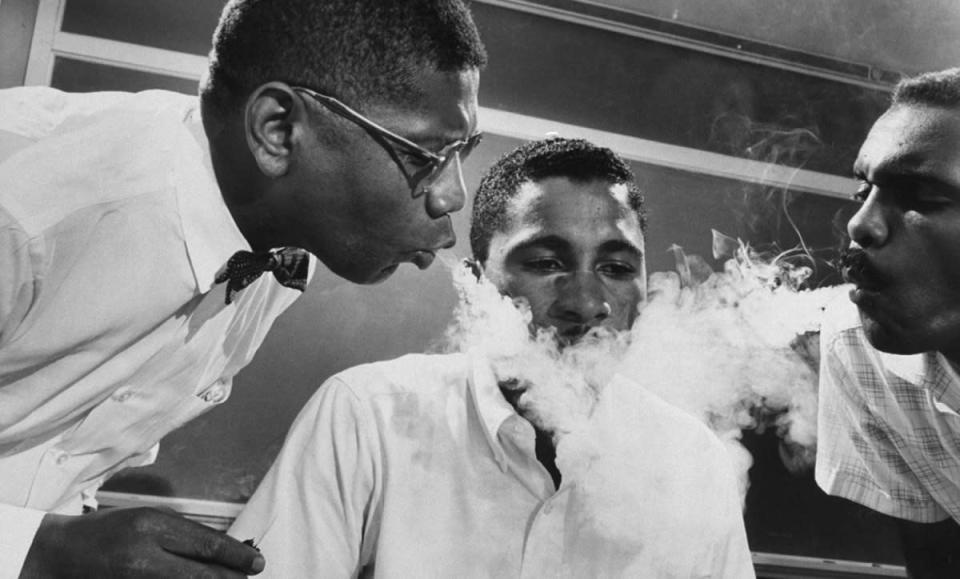 Caption from LIFE. Smoke Test, one of the harassments sit-ins have met 'on the firing line' as students call demonstrations, is administered to Virginius Thornton. His tormentors are David Gunter, an N.A.A.C.P.-student adviser (left), Leroy Hill, high school teacher. (Howard Sochurek—Time & Life Pictures/Getty Images) <br> <br> <a href="http://life.time.com/history/civil-rights-photos-from-sit-ins-and-protest-training-sessions-1960/#1" rel="nofollow noopener" target="_blank" data-ylk="slk:Click here to see the full collection at LIFE.com;elm:context_link;itc:0;sec:content-canvas" class="link ">Click here to see the full collection at LIFE.com</a>