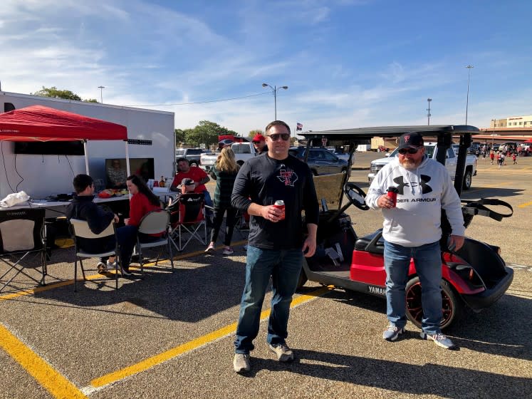 LUBBOCK, TEXAS - SAT. OCT. 24, 2020 - Car dealers Keith Kiser, 59, of Clovis, N.M., right, and Shane Scarbrough, 39, of Lubbock, left, tailgated Saturday as usual outside the Texas Tech stadium despite a local Covid-19 outbreak. "At this point in my life, I'm willing to take a few chances," Kiser said. (Molly Hennessy-Fiske / Los Angeles Times)