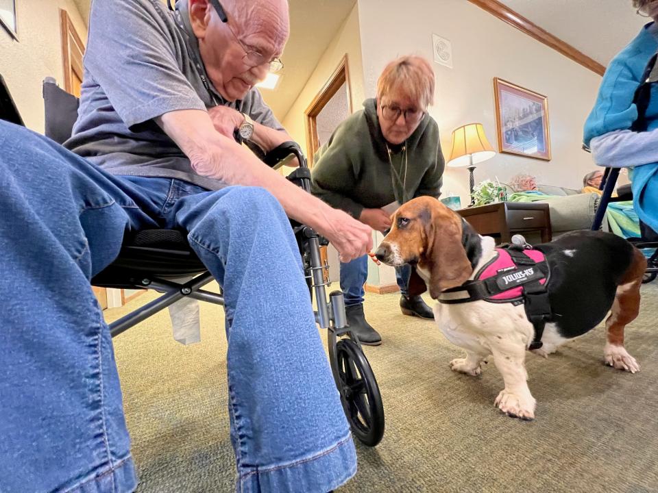 Scott Smith shares a treat with "Maggie" on Thusday at Trustwell Living at Mansfield Place.