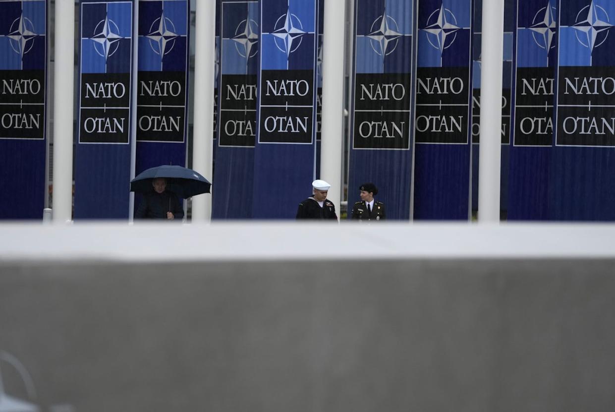 Two military personnel walk by NATO banners before a wreath-laying ceremony at NATO's headquarters in Brussels on April 4, 2024. <a href="https://newsroom.ap.org/detail/BelgiumNATOAnniversary/3fa1c7bc3d874af281719cabeb915eb4" rel="nofollow noopener" target="_blank" data-ylk="slk:Virginia Mayo/AP Photo;elm:context_link;itc:0;sec:content-canvas" class="link ">Virginia Mayo/AP Photo</a>