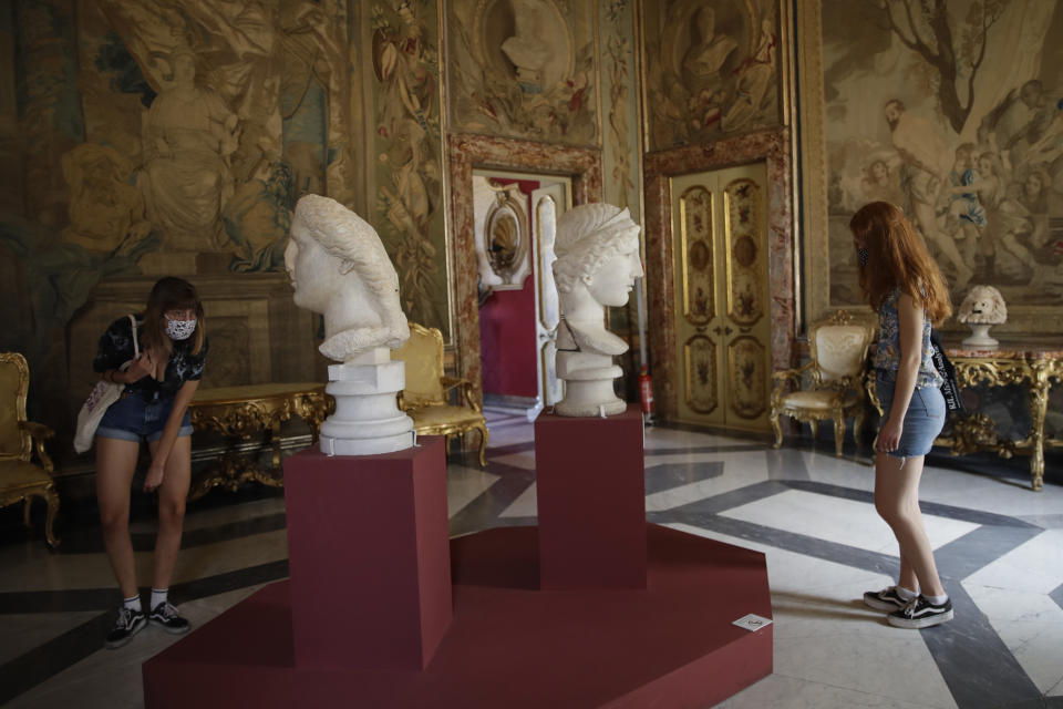 Visitantes con máscaras para prevenir el COVID-19 observan esculturas de mármol del siglo I d.C. en los Museos Capitolinos de Roma el martes 19 de mayo de 2020. Los museos han reabierto dudosos a medida que se relajan las medidas de confinamiento por el coronavirus, pero los expertos señalan que uno de cada ocho museos podría cerrar permanentemente por la pandemia. (Foto AP/Alessandra Tarantino)