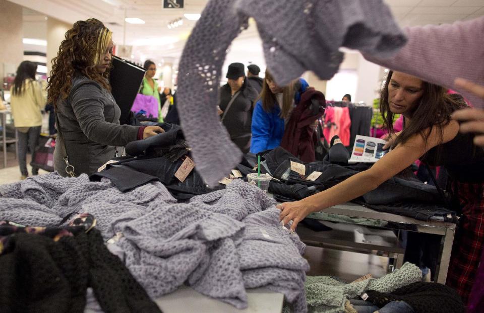 Shoppers rummage through a pile of sweaters on sale at a J.C. Penney store, Friday, Nov. 23, 2012, in Las Vegas. Despite a surge of resistance as the sales drew near, with scolding editorials and protests by retail employees and reminders of frantic tramplings past, Black Friday's grip on America may be stronger than ever. (AP Photo/Julie Jacobson)