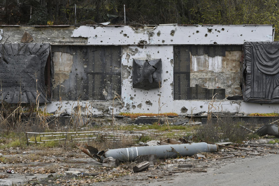 A part of a rocket lies in front of a WWII memorial damaged by fighting in the village of Dolyna, Donetsk region, Ukraine, Thursday, Nov. 3, 2022. (AP Photo/Andriy Andriyenko)