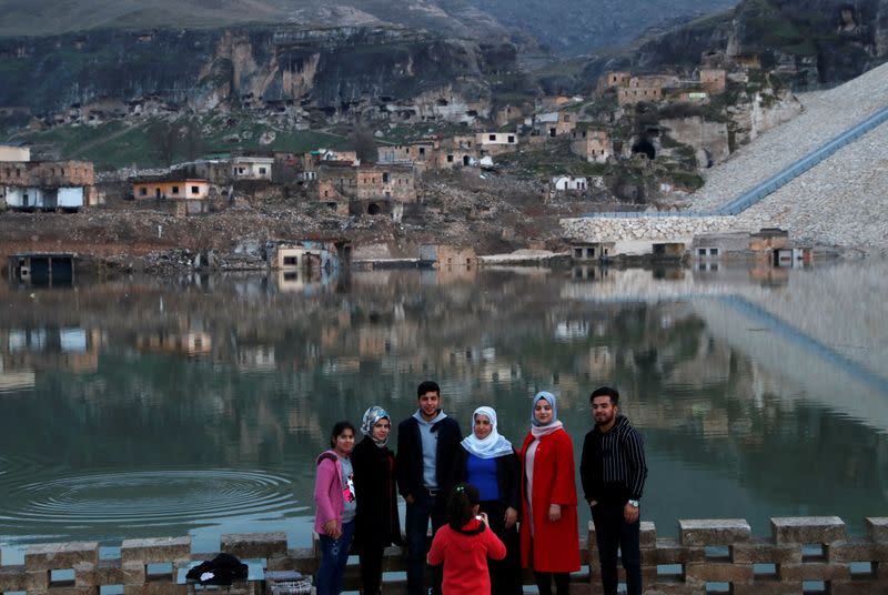 People pose for a souvenir photo at a tea house by the Tigris River in Hasankeyf