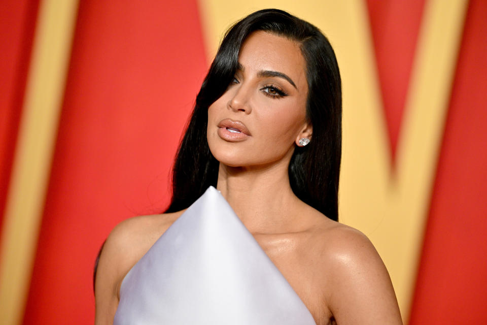 Kim Kardashian wearing a white off-shoulder gown at an event