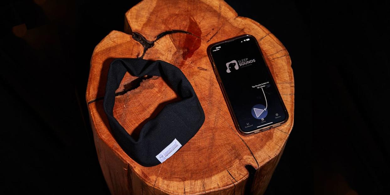 acousticsheep sleepphones wireless sleep headphones on a table next to a phone that is connected to the product