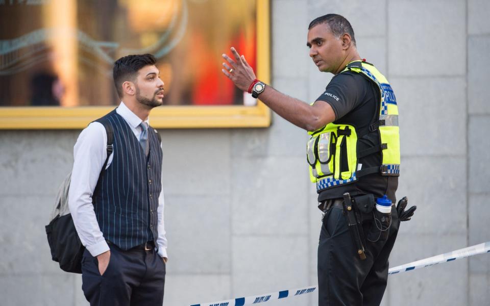 A police officer speaks to a member of the public in the London Bridge area - Credit: PA