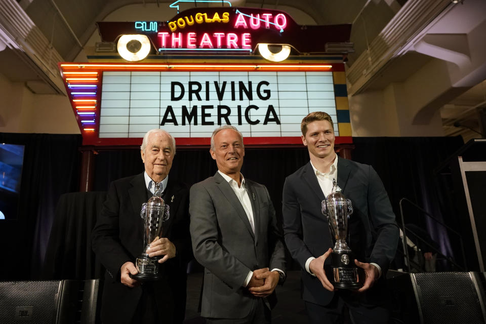 Fred Lissalde, center, president and CEO of BorgWarner; Roger Penske, team owner, left, and driver Josef Newgarden, right, winner of the 2023 Indianapolis 500, hold their Baby Borg driver's and team owner's trophies, Tuesday, Jan. 23, 2024 in Dearborn, Mich. (AP Photo/Carlos Osorio)