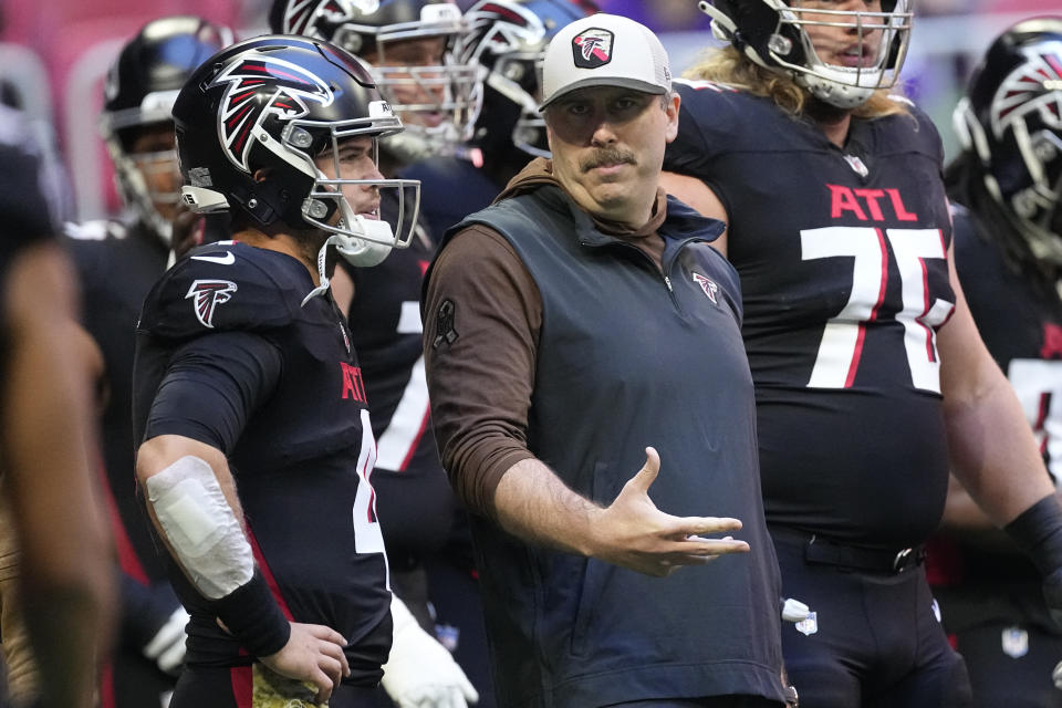 Atlanta Falcons head coach Arthur Smith, right, speaks to quarterback Taylor Heinicke, left, before an NFL football game against the Minnesota Vikings, Sunday, Nov. 5, 2023, in Atlanta. (AP Photo/John Bazemore)