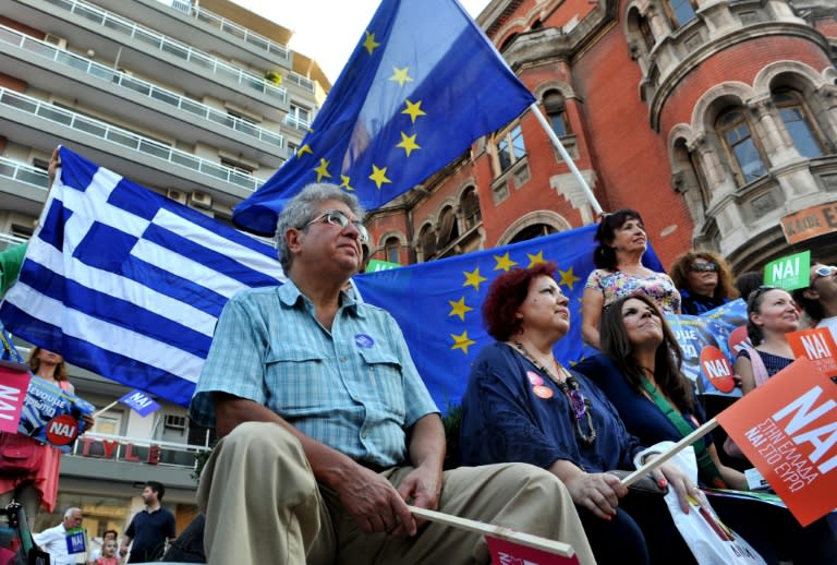 Pro-European Union protesters hold EU and Greek flags and placards reading "yes" during a demonstration in Thessaloniki on July 2, 2015