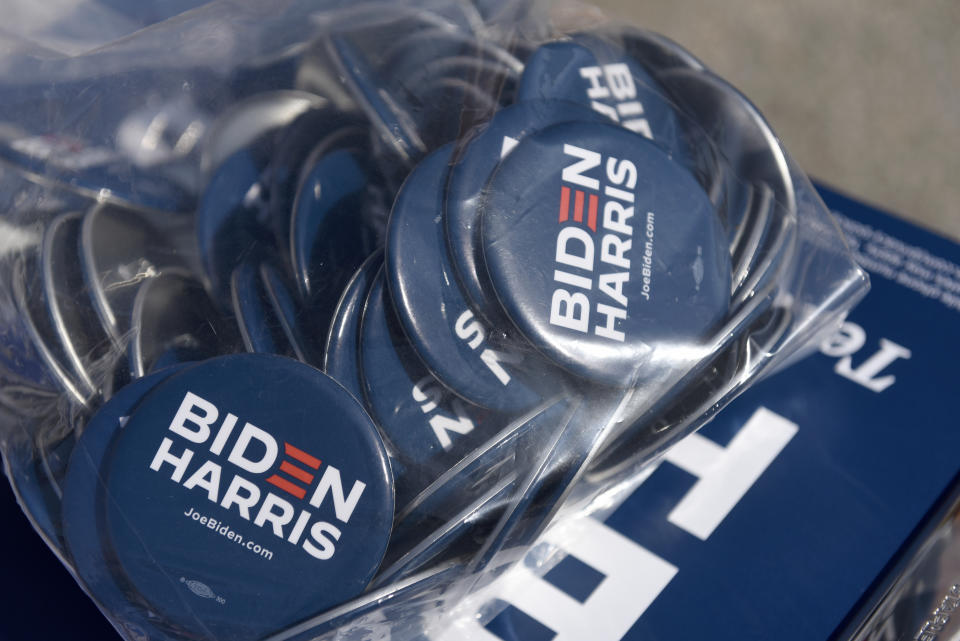 Biden/Harris pins are displayed by the Joe Biden campaign are seen on a table at an early voting satellite location at the Anne B. Day elementary school, Thursday, Oct. 15, 2020, in Philadelphia. (AP Photo/Michael Perez)