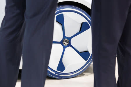 People stand in front of a Volkswagen I.D. electric vehicle shown at a news conference in Guangzhou, China November 17, 2016. REUTERS/Bobby Yip