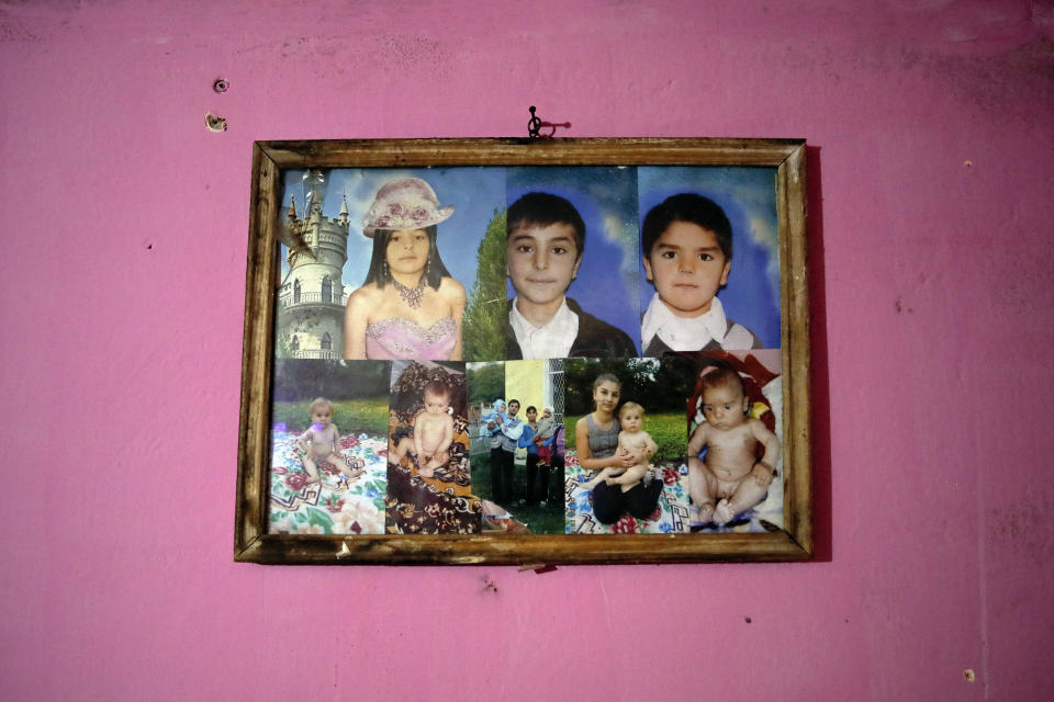 A frame with several pictures of children assisted by Valeriu Nicola, hangs on a wall in their family home in Nucsoara, Romania, Saturday, Jan. 9, 2021. A gentle hero to many in Romania, Valeriu Nicolae says that, at heart, he is more like former NBA star Michael Jordan — highly competitive and eager to improve in what he does best. In Nicolae’s case that is helping others. The rights activist has earned praise for his tireless campaign to change for the better the lives of the Balkan country’s poorest and underprivileged residents, particularly the children. (AP Photo/Vadim Ghirda)