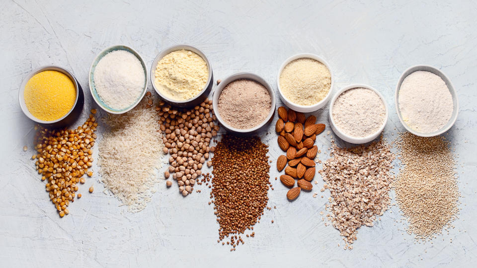 Various gluten free flour - chickpeas, rice, buckwheat, quinoa, almond, corn, oatmeal on grey background.