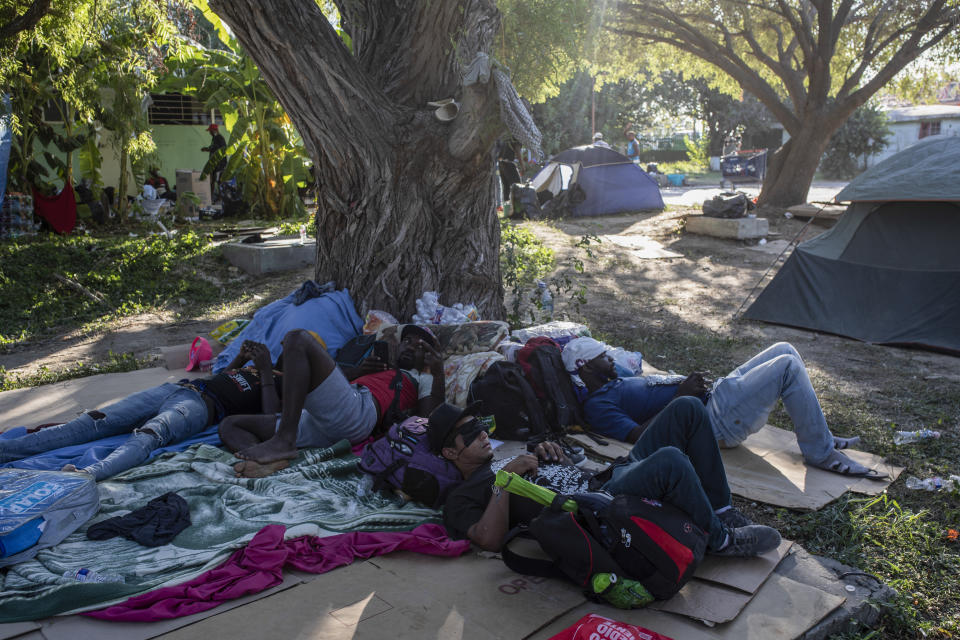 Migrants rest under the shade of a tree in Ciudad Acuna, Mexico, Friday, Sept. 24, 2021, across the Rio Grande from Del Rio, Texas. No migrants remained Friday at the Texas border encampment in Del Rio where almost 15,000 people — most of them Haitians — had converged just days earlier seeking asylum, local and federal officials said. (AP Photo/Felix Marquez)