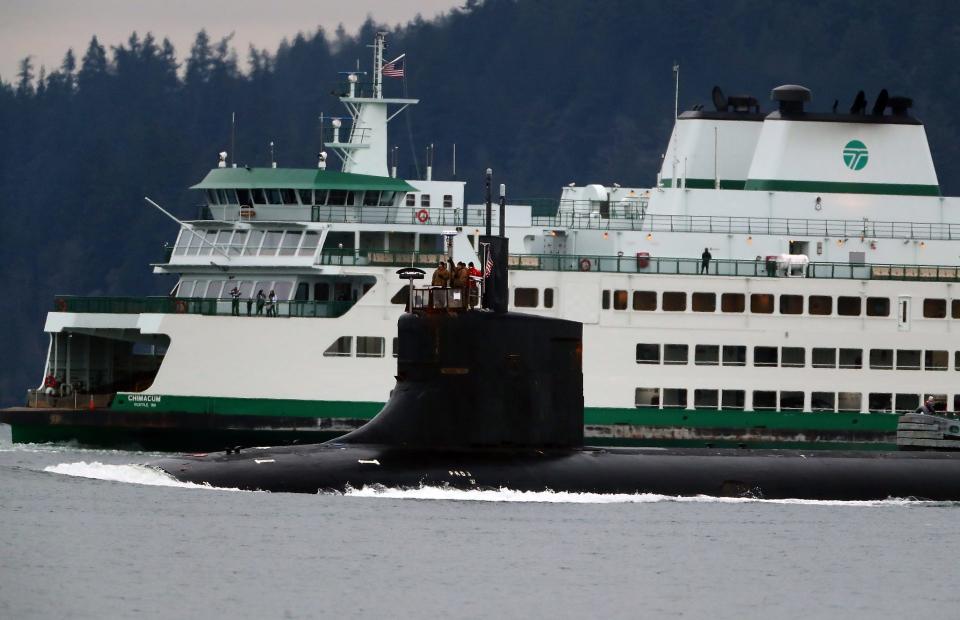 The USS Connecticut passes the Washington State Ferry Chimacum as the sub heads for Naval Base Kitsap on Tuesday, Dec. 21, 2021.
