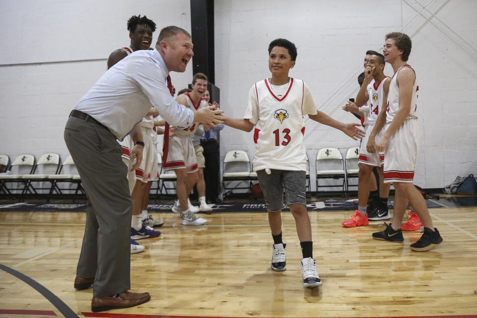 Geo Ortiz, 15, runs onto the court while high-fiving Jupiter Christian Head Coach Brian Mullican during team introductions before the start of the game between Jupiter Christian and the King's Academy in Jupiter, FL, on Friday, January 17, 2020. Jupiter Christian partnered with the Chasin' a Dream Foundation to honor Ortiz, who was diagnosed with ALL-Leukemia in 2018, as an honorary sixth man on the team.