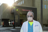 Dr. Stephen Anderson, a physician who works in the Emergency Department at the MultiCare Auburn Medical Center in Auburn, Wash., wears a mask and face shield as he poses for a photo before starting his shift, Tuesday, March 17, 2020, in Auburn, Wash., south of Seattle. Anderson said he writes messages on his shields to identify them as his, and this morning he chose the phrase "Stay Safe." “There just are not enough masks to go around at my hospital,” said Dr. Anderson. "I've got a two-day supply of masks so we're trying to be conservative. You get one in the morning. You clean it and reuse it." (AP Photo/Ted S. Warren)