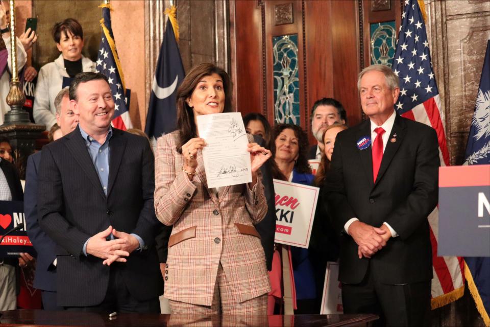 White House hopeful Nikki Haley holds up a filing to appear on the South Carolina Republican presidential primary ballot at the South Carolina State House on Monday, Oct. 30, 2023, in Columbia, S.C. The former South Carolina governor formally filed Monday to appear on the state's Republican presidential primary ballot.